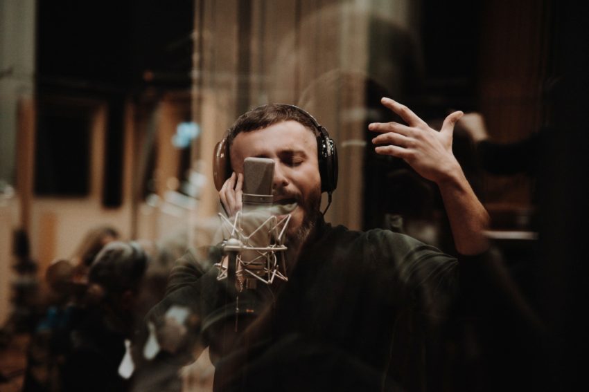 Vasil in a studio. He is standing in front of a microphone.